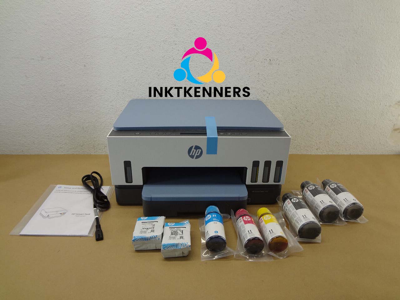 Een HP-printer en verschillende kleuren cartridges op een tafel